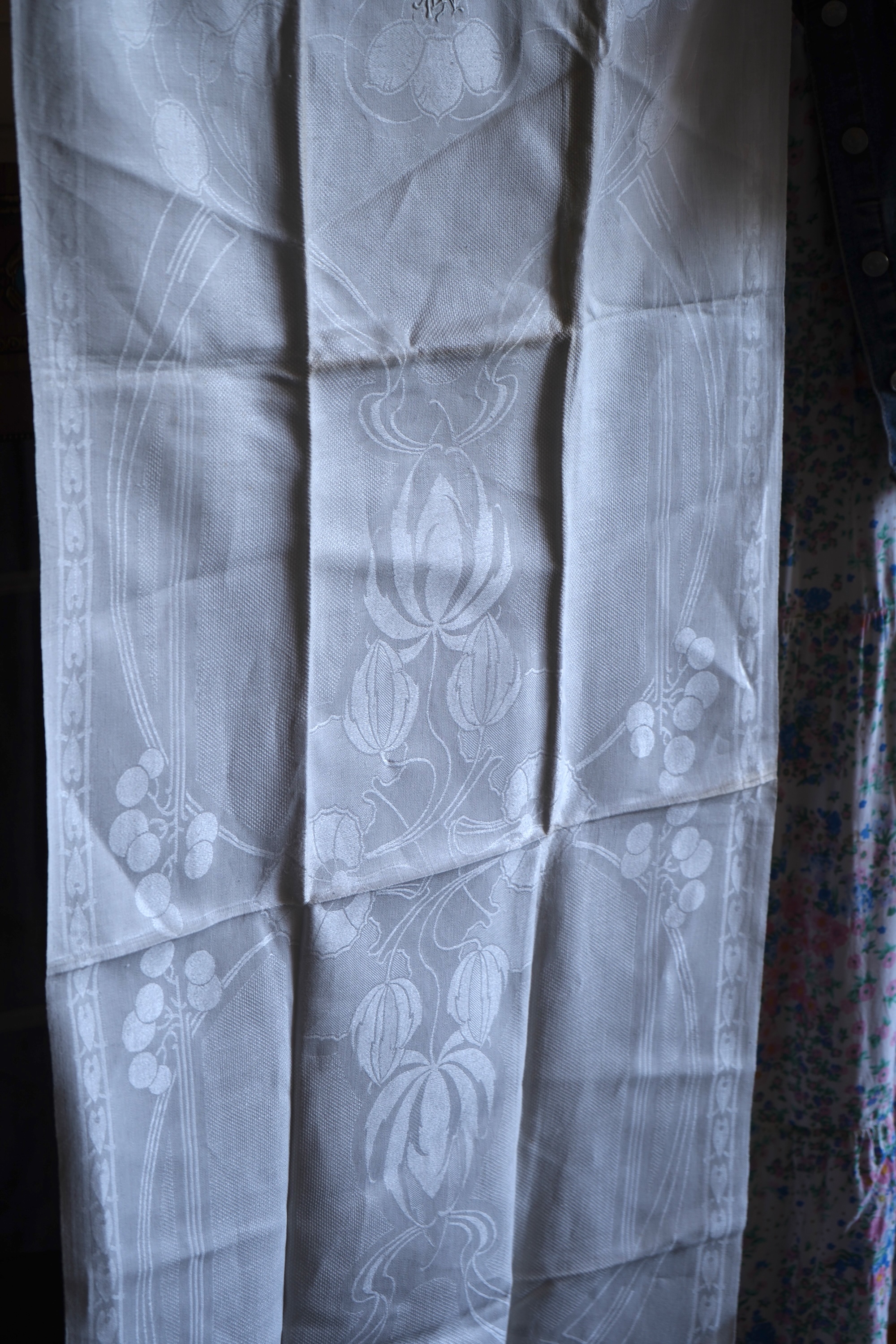 A set of four large Art Nouveau, unused white damask woven hand towels. The pattern having strong Archibald Knox and Walter Crane design elements; with trailing Honesty seeds and Tulip flower heads, these motifs much use